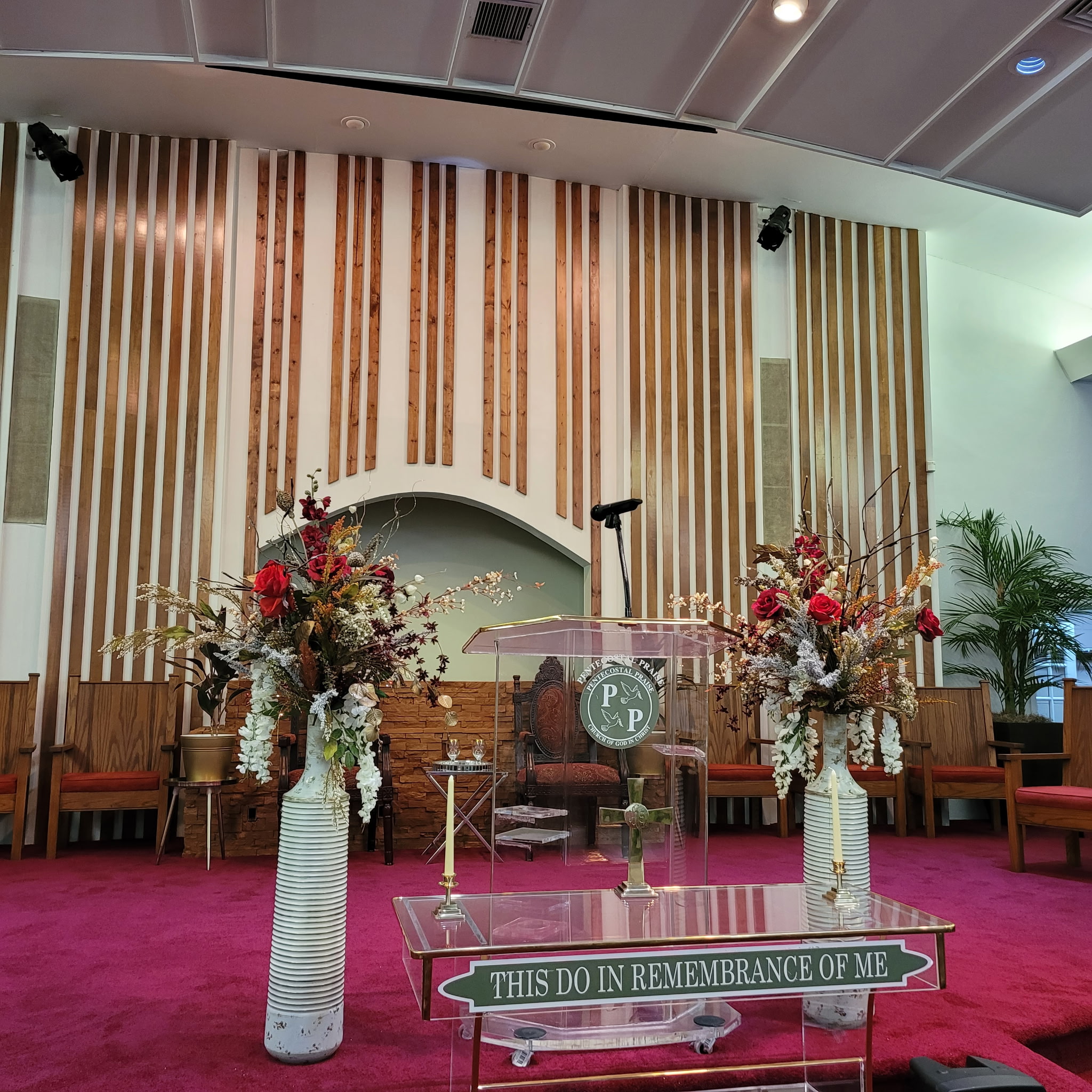 The Pentecostal Praise Community Church stage, pulpit, and floral arrangements